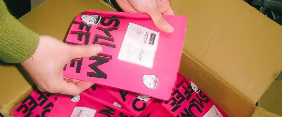 Hands lifting bags of Asylum Coffee out of a shipping box